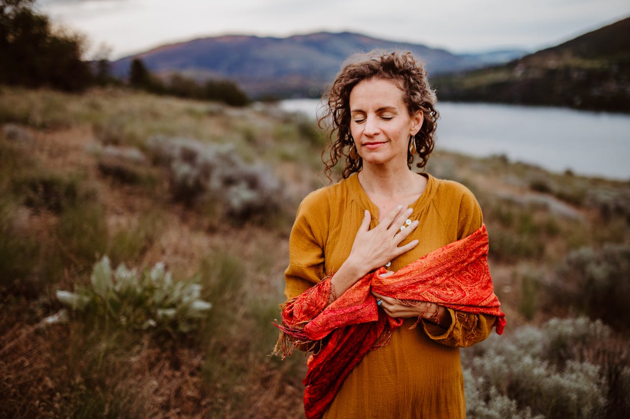 Woman in serene meditation near a lake, embracing wellness and peace.